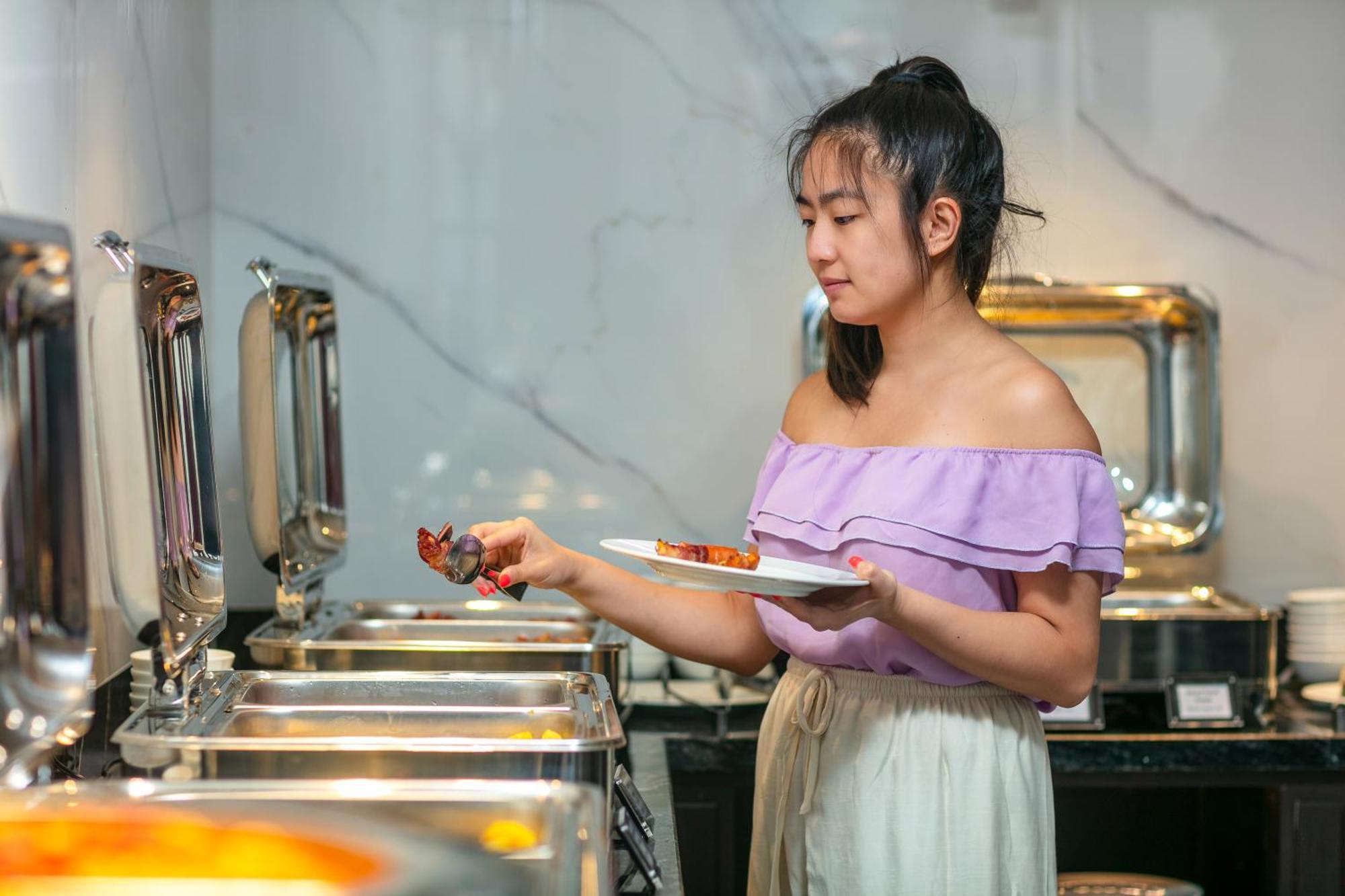 May De Ville Lakeside Hotel Hanoi Exterior photo A woman serving herself at a buffet